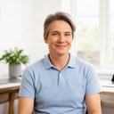 Parent seated in a bright home office after discussing a teenager's esports coaching progress
